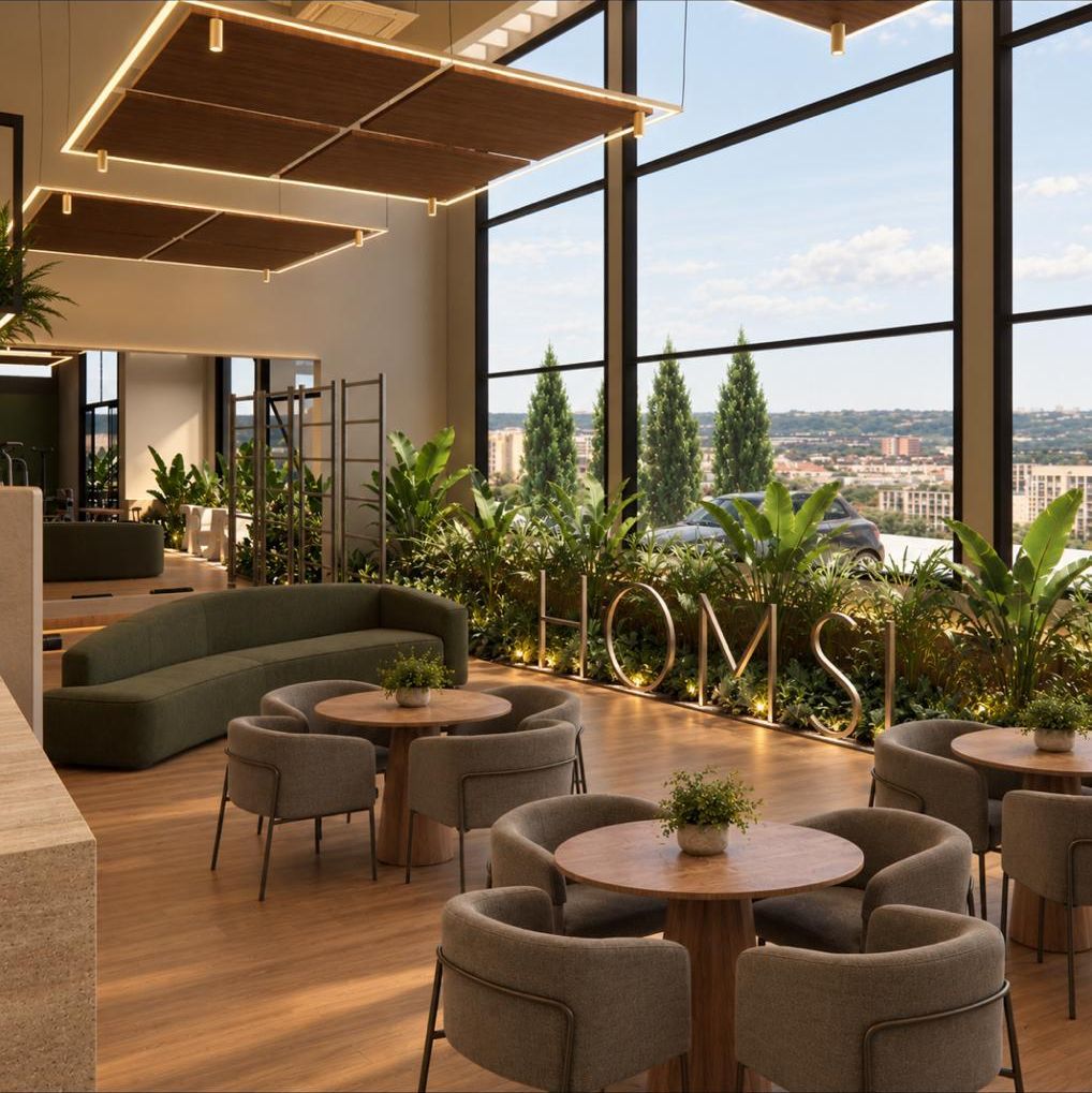 Lounge interno com poltronas e vista da cidade